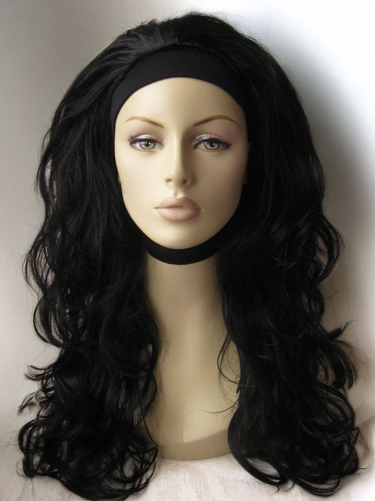 Black wig on a mannequin head against a white background. Black curly half wig hairpiece (volume wig), big loose curls: Suzie