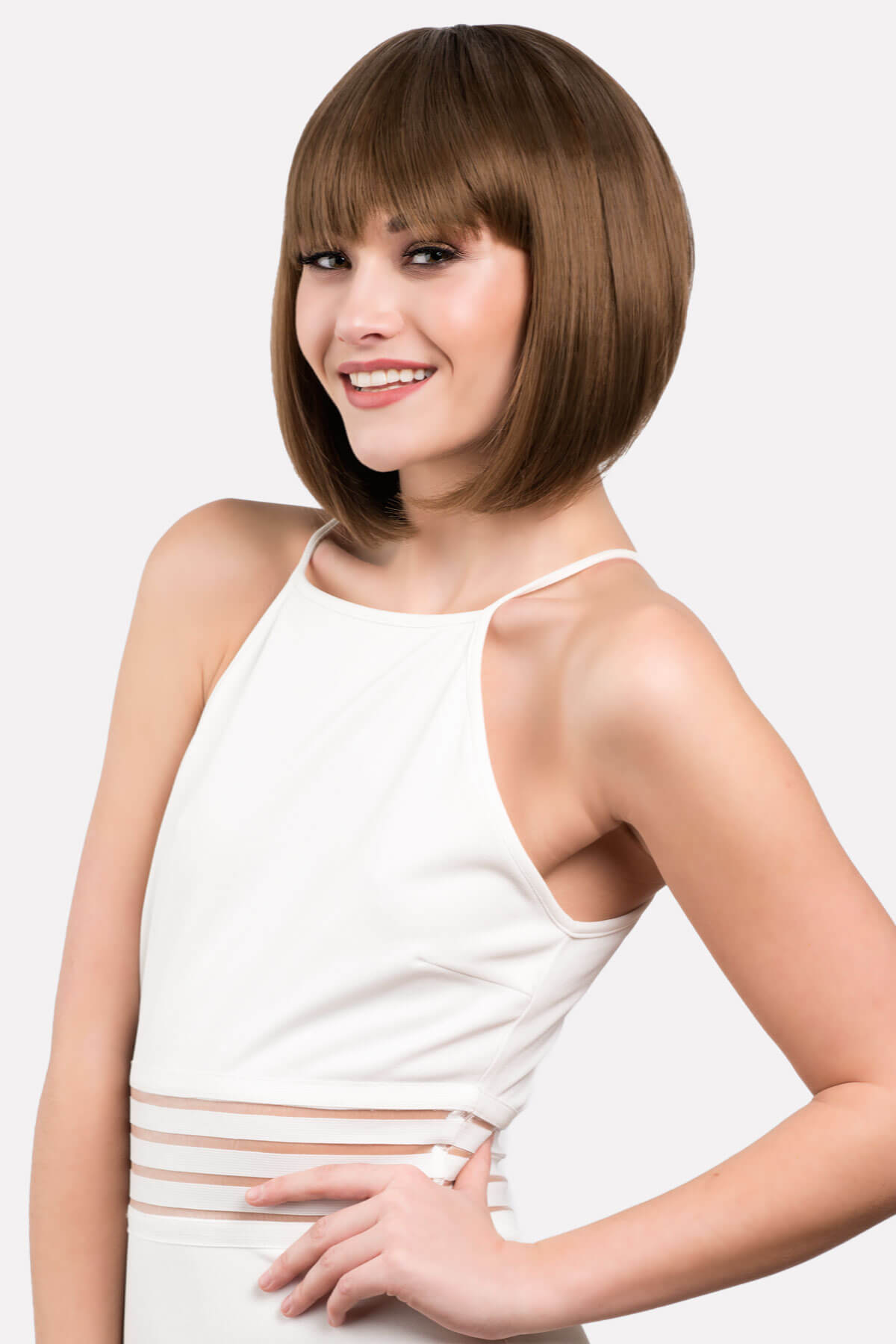 Woman with a stylish haircut wearing a white top on a light gray background. Brown inverted bob wig: Colette light brown 12