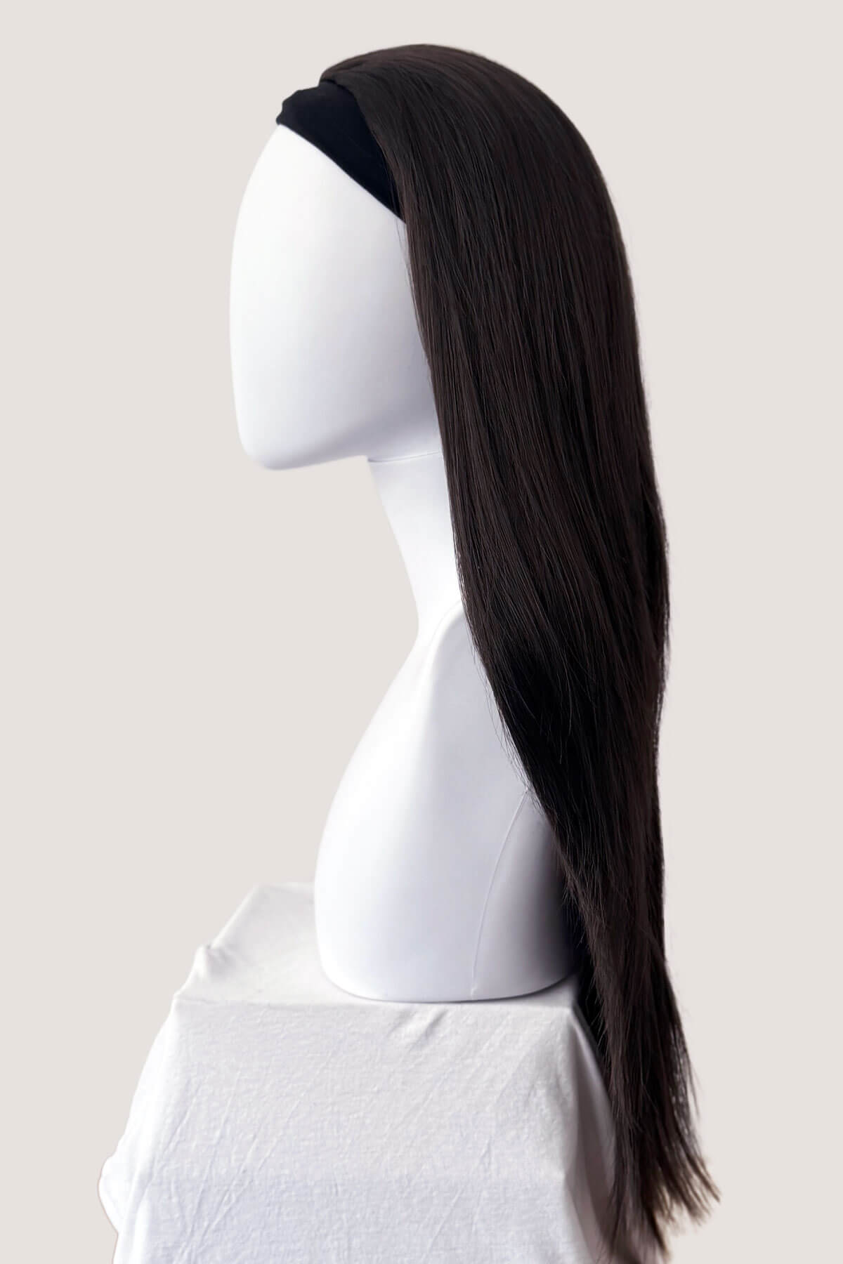 Mannequin head with a long black wig on a plain background. Straight brown half wig hairpiece extension, long: Faye dark brown 6