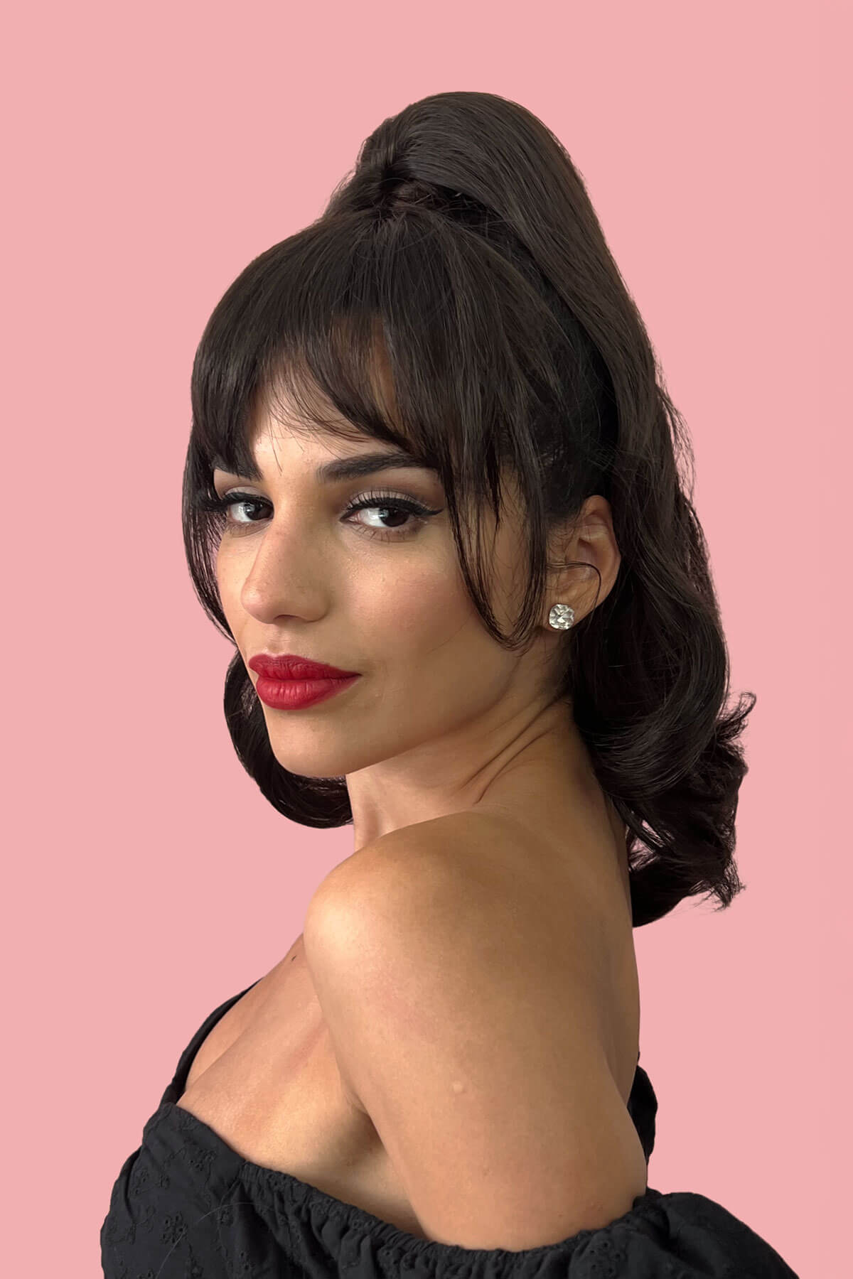 Woman with styled hair and red lipstick against a pink background. Clip in fringe hairpiece/clip-in bangs, gently feathered with face framing whisps: Delia dark brown 4