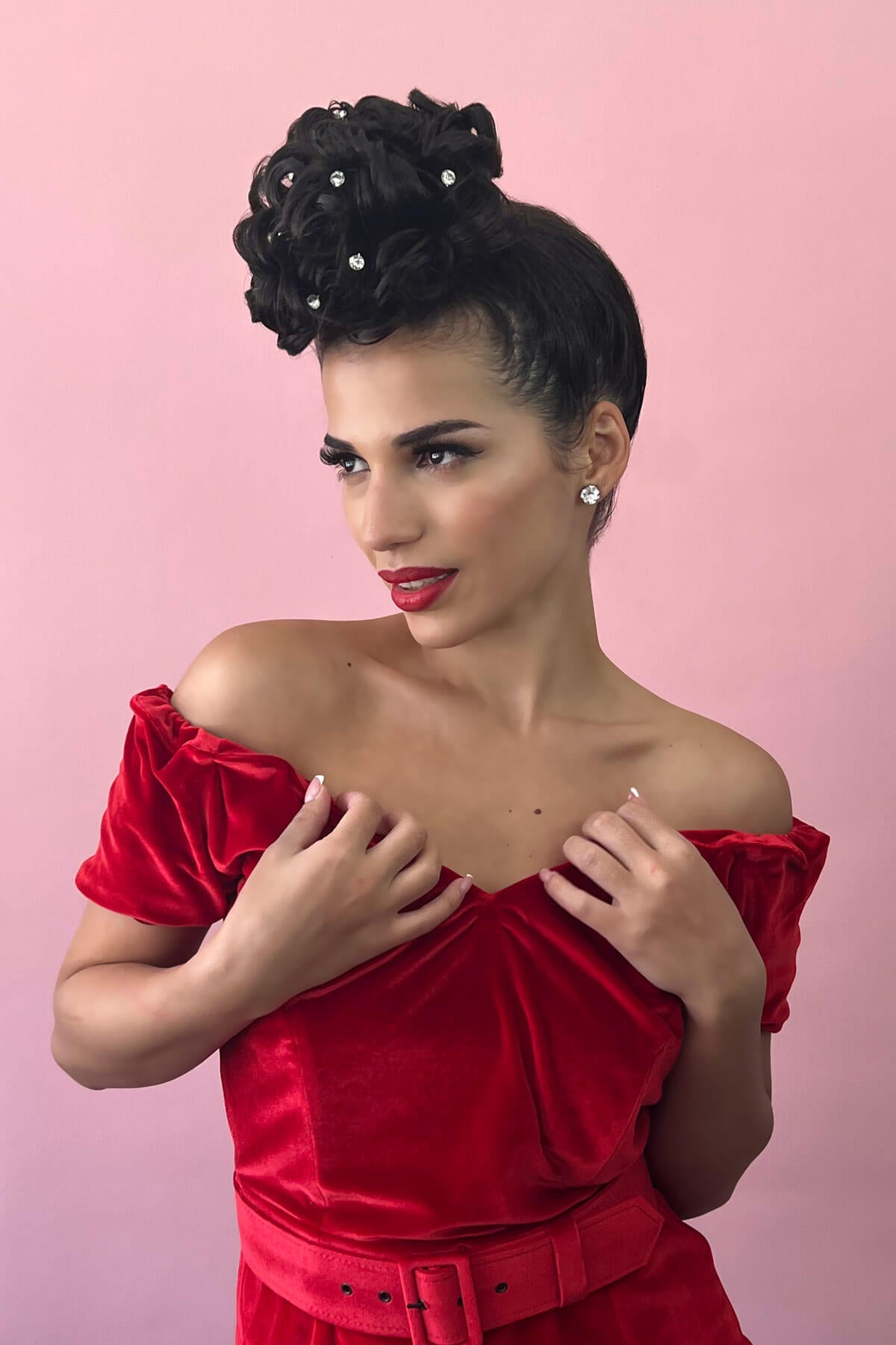 Woman wearing a red off-shoulder dress with a pink background. Hair poodle clip-in hairpiece bun vintage style 1950s: Lucille dark chocolate brown 6