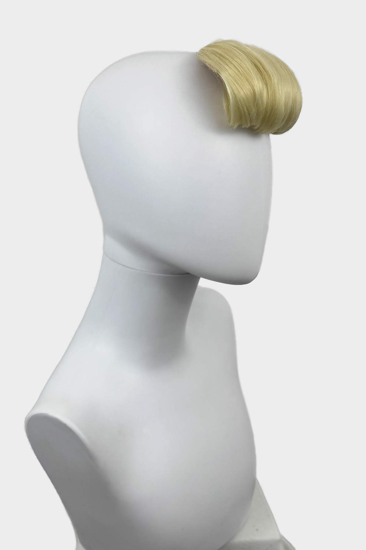 Mannequin head with a blonde hairpiece on a white background. Victory roll fringe/bangs hairpiece, 1950s vintage style: Rosa light blonde 613