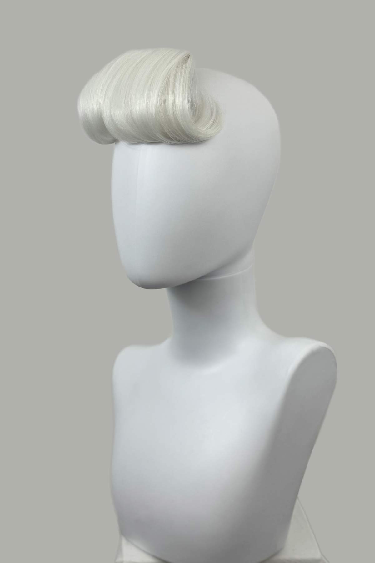 Mannequin head with a white wig on a gray background. Victory roll fringe/bangs hairpiece, 1950s vintage style: Rosa platinum 1001