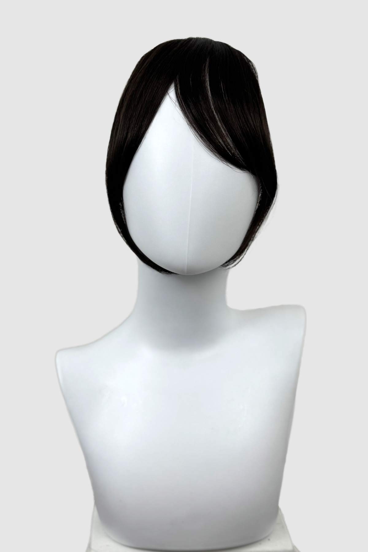 Black wig on a mannequin head against a white background. Clip in fringe hairpiece/clip-in curtain bangs, with long, face framing wisps: Sabrina dark brown 4