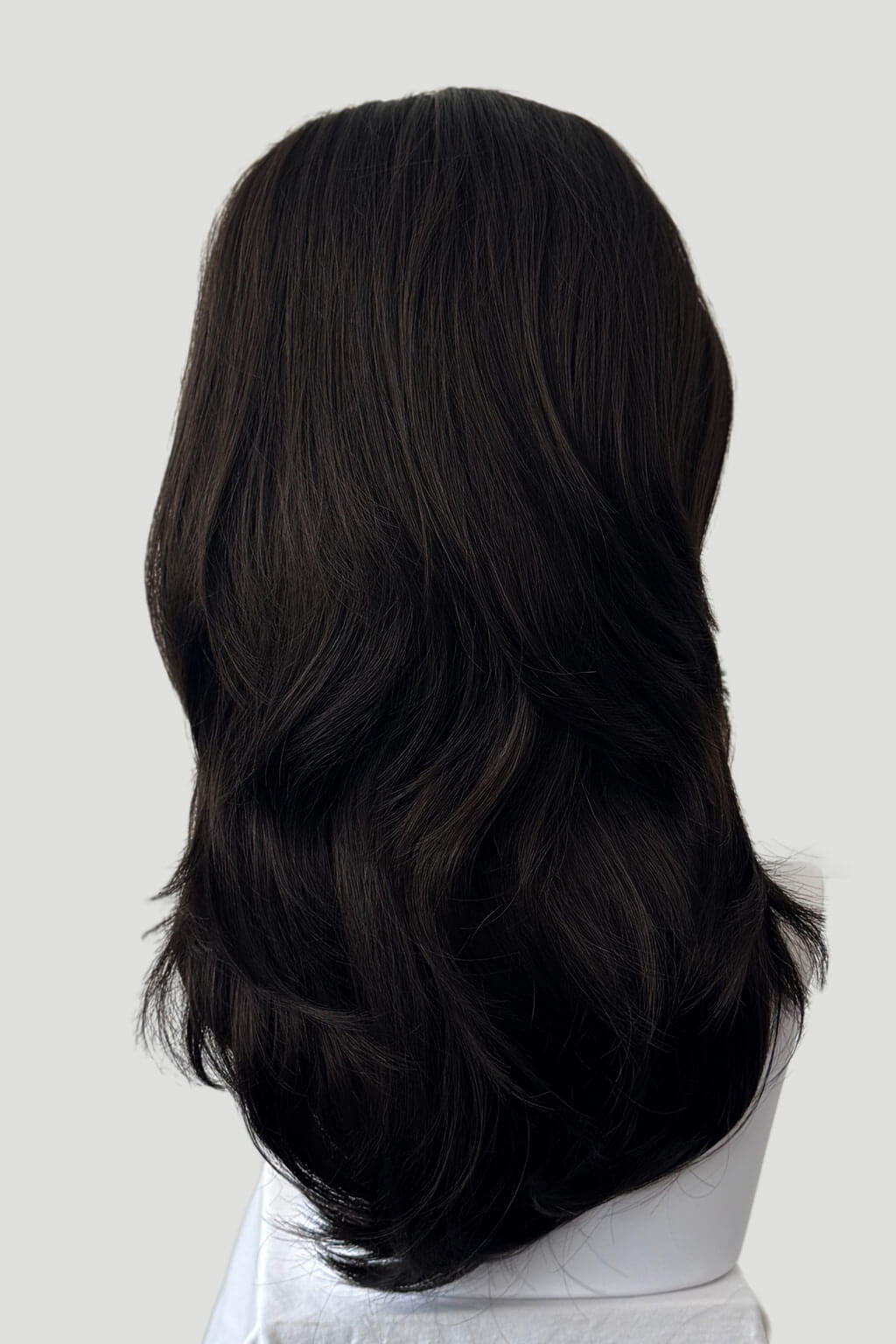 Dark brown hair extension on a mannequin head against a white background. 1960s style hair, high crown long straight and layered half wig: Juliette dark brown 4