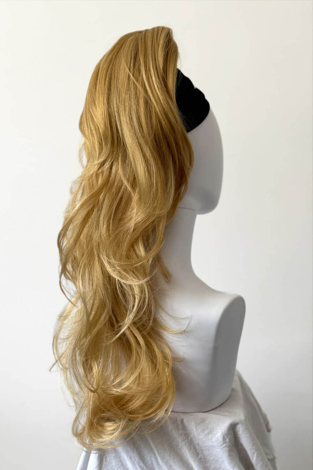 Long wavy blonde wig with a half-up style and side part, displayed on a white mannequin head against a plain light background. Clip-in ponytail hairpiece extension: Olivia golden blonde 24BH613