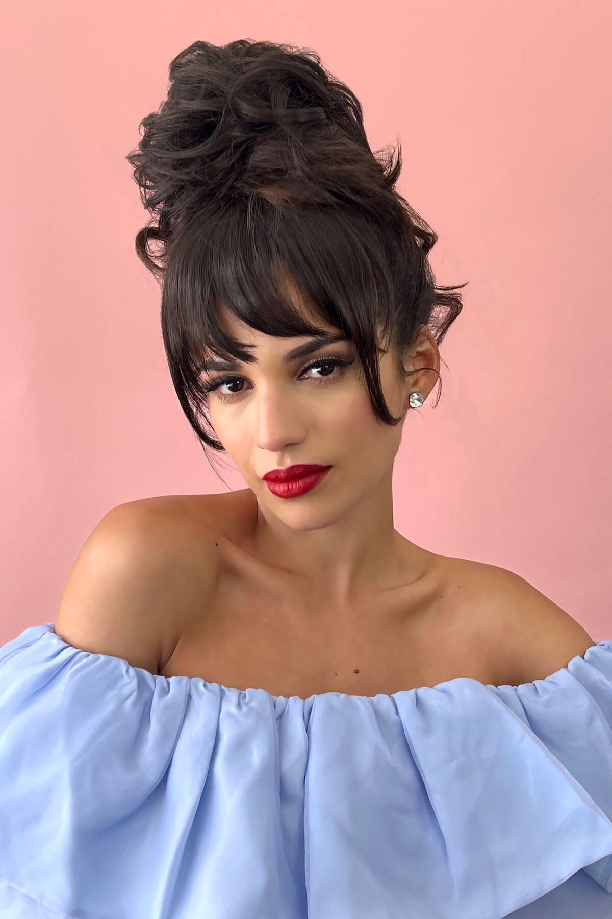 Woman with styled hair and red lipstick against a pink background. Scrunchie bun hairpiece, easy updo messy bun: Betsy dark brown 4