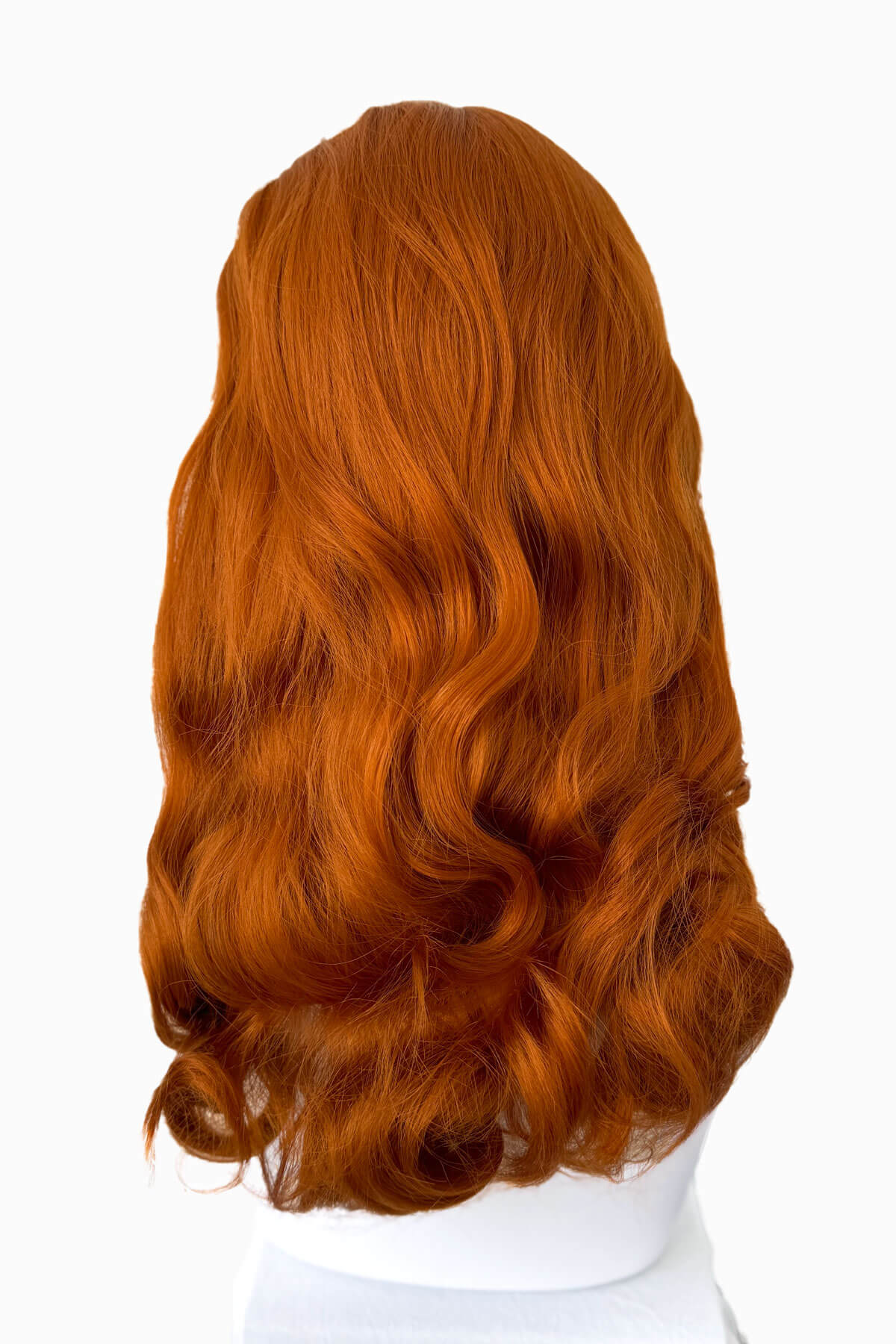 Ginger red wig on a white mannequin head with a white background. 1950s style half wig hairpiece with beautiful waves: Morgana ginger