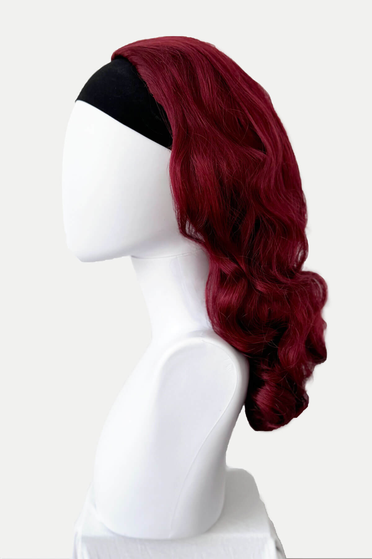Red wig on a mannequin head against a white background. 1950s style half wig hairpiece with beautiful waves: Morgana red 39