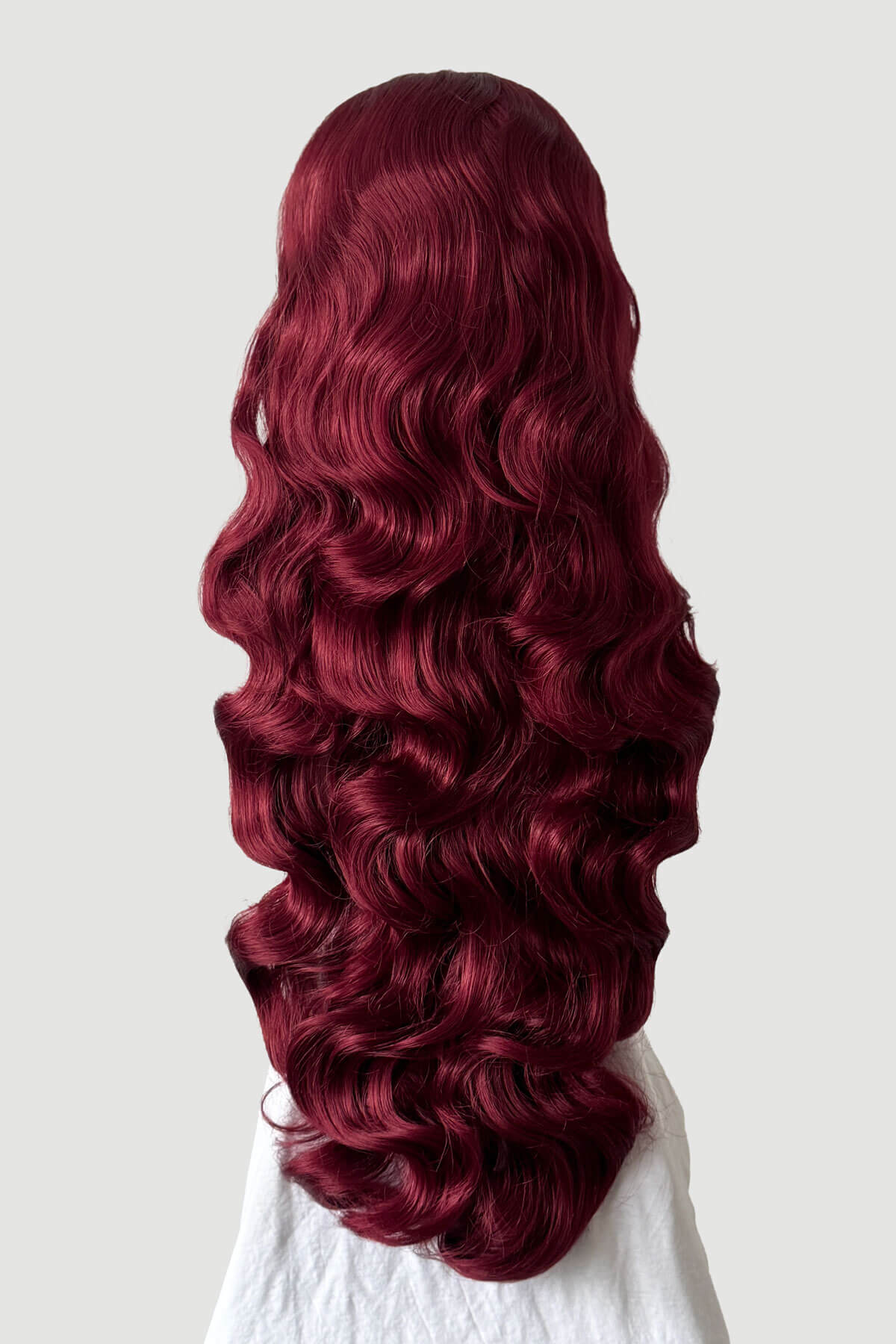 Mannequin head with long, red hair styled in a ponytail on a plain background. Ultra long half wig with hollywood waves. cherry red 39