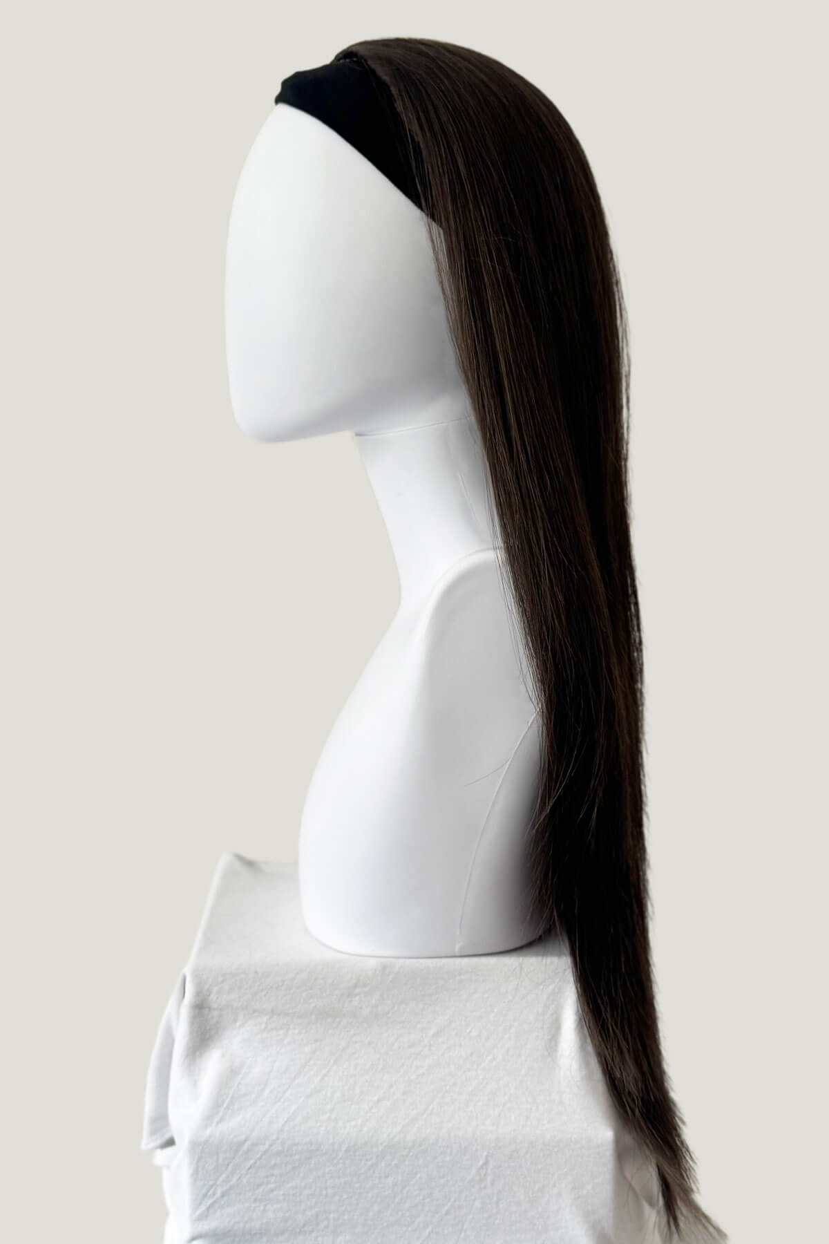 Mannequin head with a long brown ponytail on a plain background. Straight brown half wig hairpiece extension, long: Faye chestnut brown 8