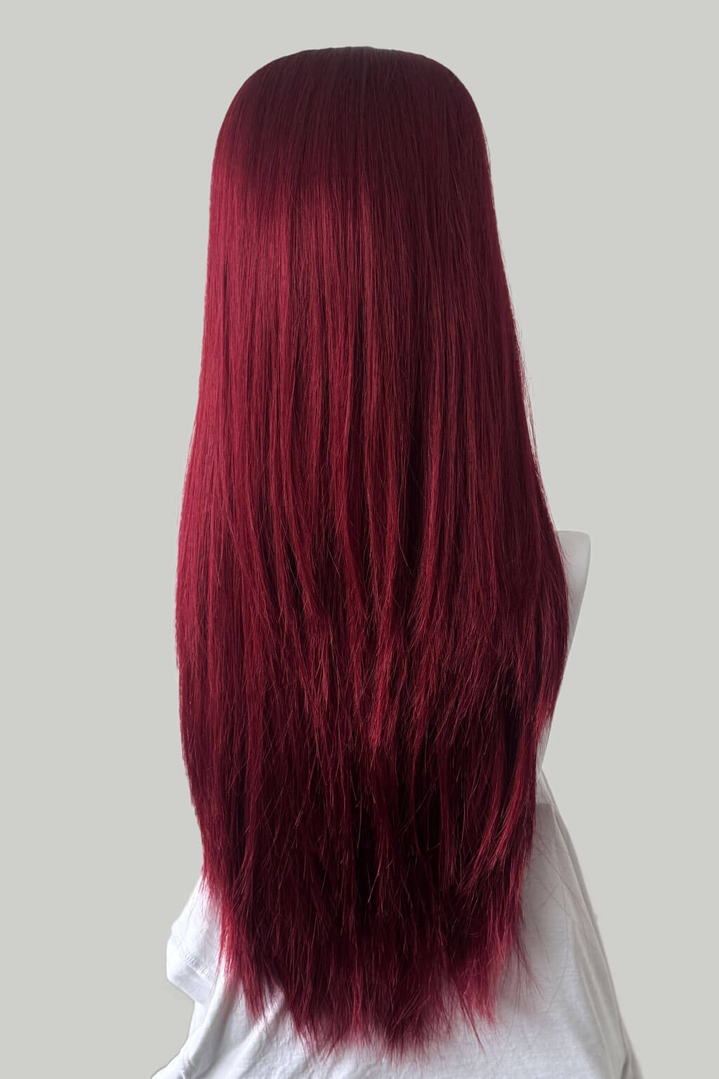 Red wig on a mannequin head against a plain background. 1960s style hair, high crown long straight half wig: Andrea cherry red 39