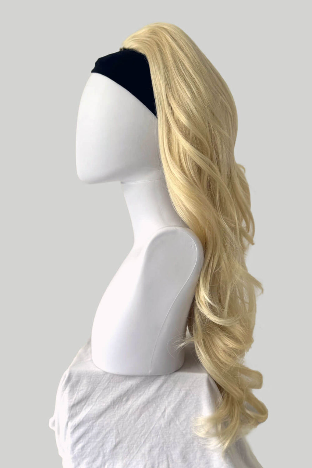 Blonde wig on a mannequin head against a plain background. High crown long, wavy half wig and volume ring: Bardot blonde 613