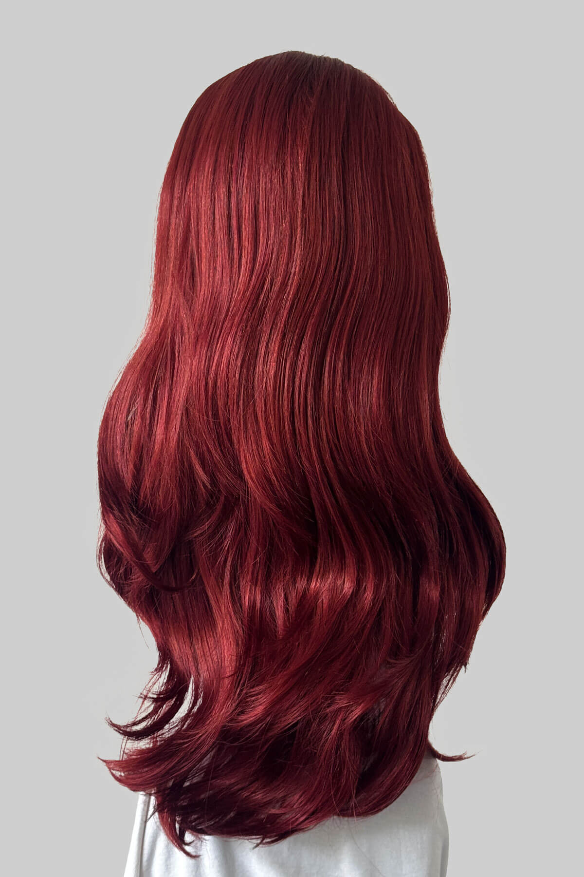 A long, wavy half wig in red displayed on a white mannequin head against a light grey background. Claudia - Volume Boosting Long Gentle Bouncy Layered Half wig copper and dark cherry red 350/39