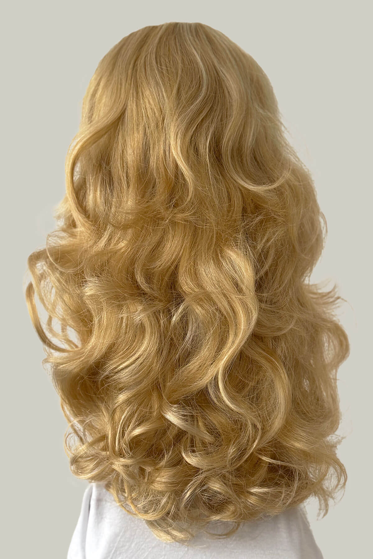Blonde wig with wavy hair on a plain background. Curly blonde half wig hairpiece extension (3/4 wig), long: Meana honey blonde 24BH613