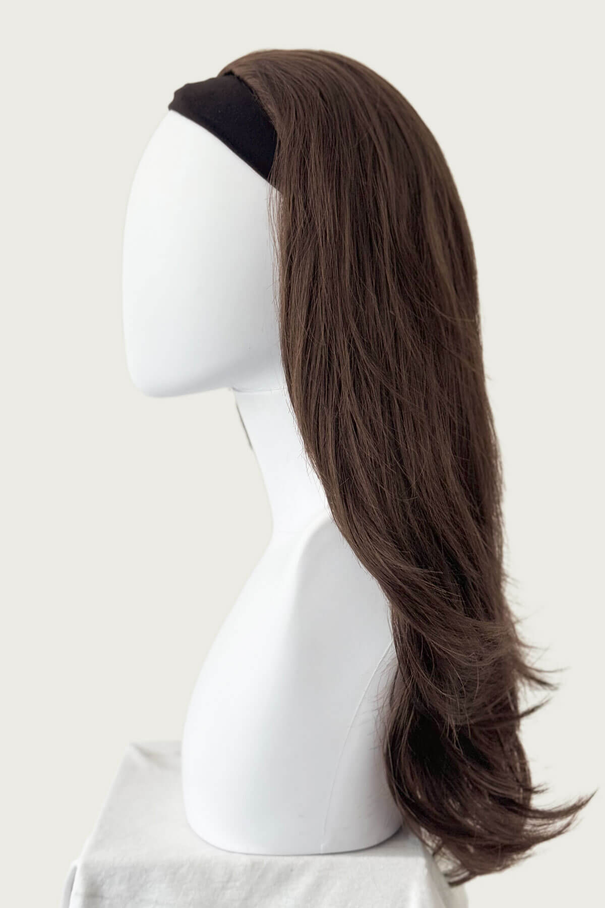 Brown wig on a mannequin head against a white background. Brown half wig hairpiece (3/4 wig), gently layered: Briar chestnut brown 8