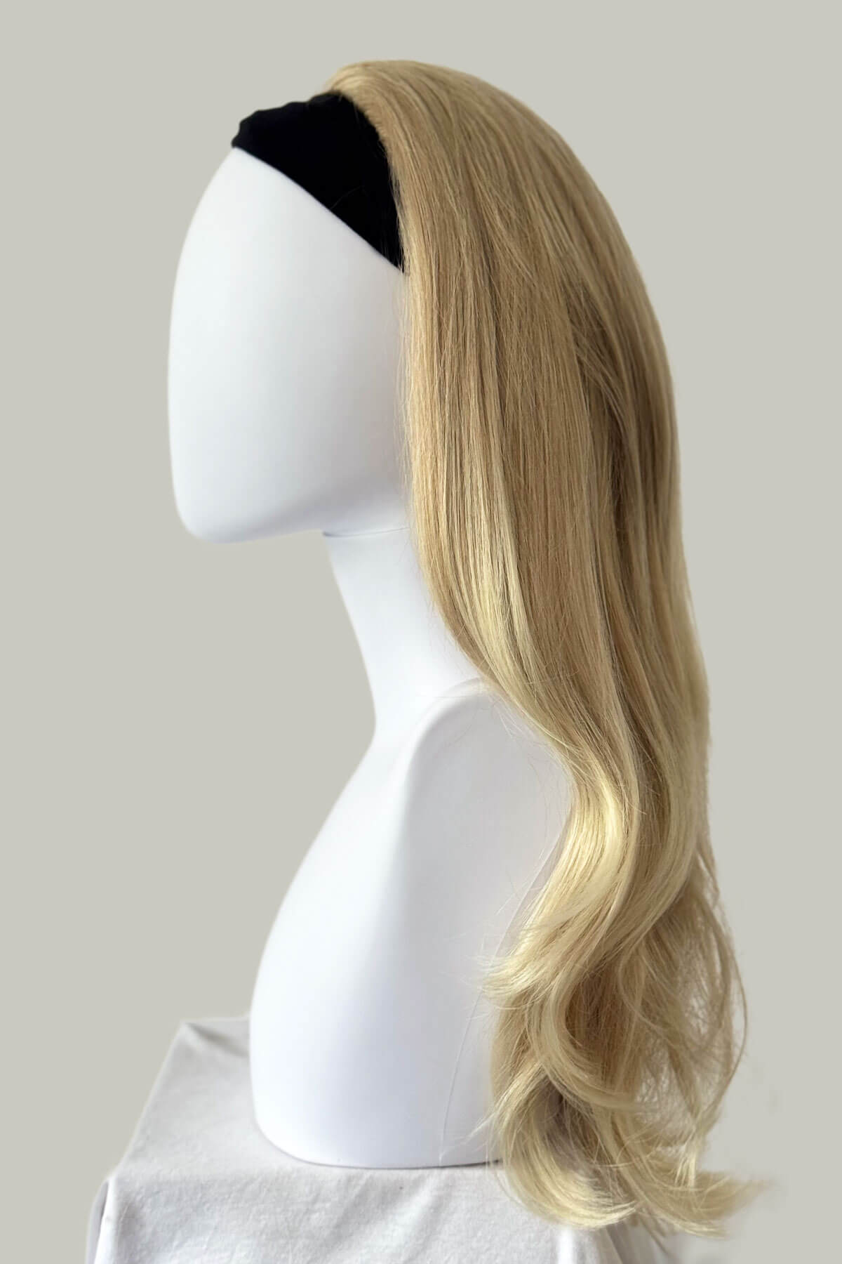 Blonde wig on a mannequin head against a plain background. Straight blonde half wig hairpiece (3/4 wig), layered: Autumn ash blonde to light blonde 613T24