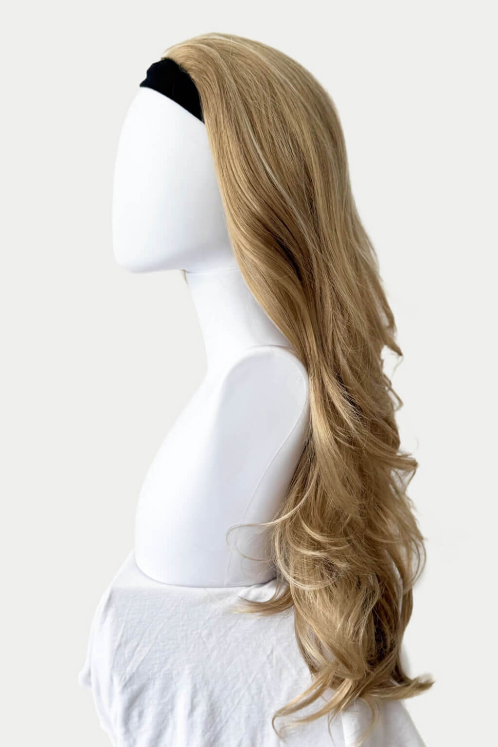 A long, wavy blonde wig with a black headband, displayed on a white mannequin head against a plain white background. Blonde half wig hairpiece (3/4 wig), loose curls: Suki blonde 24H613