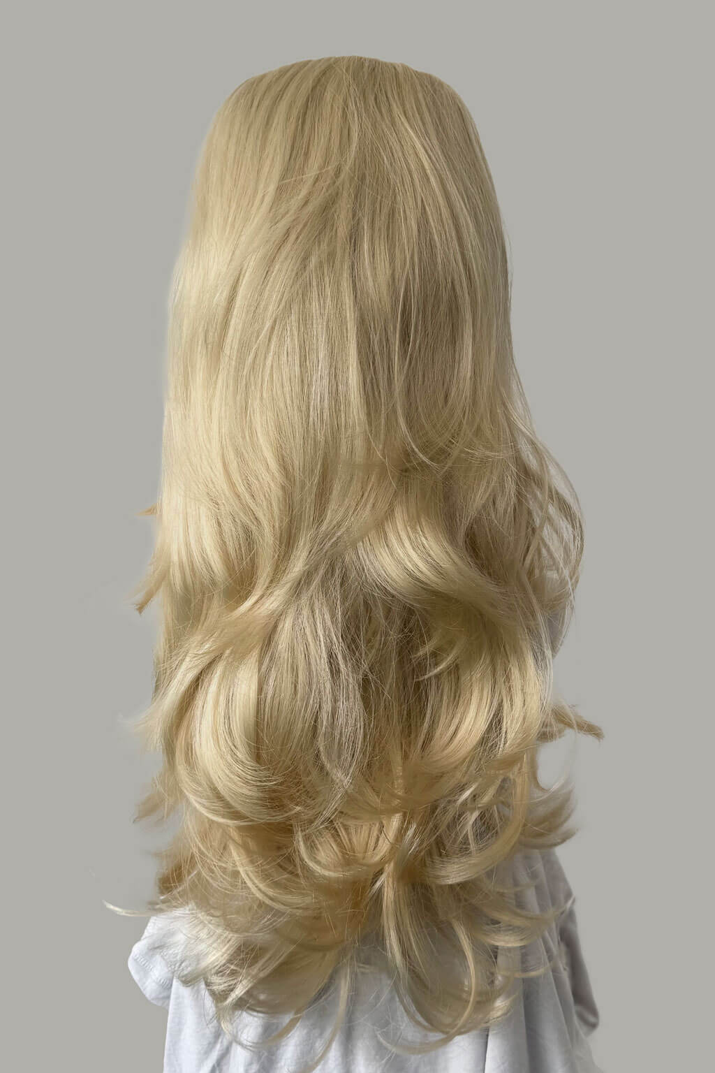 Blonde wig with wavy hair on a gray background - High crown long, layered half wig and volume ring: Helena champagne blonde 613