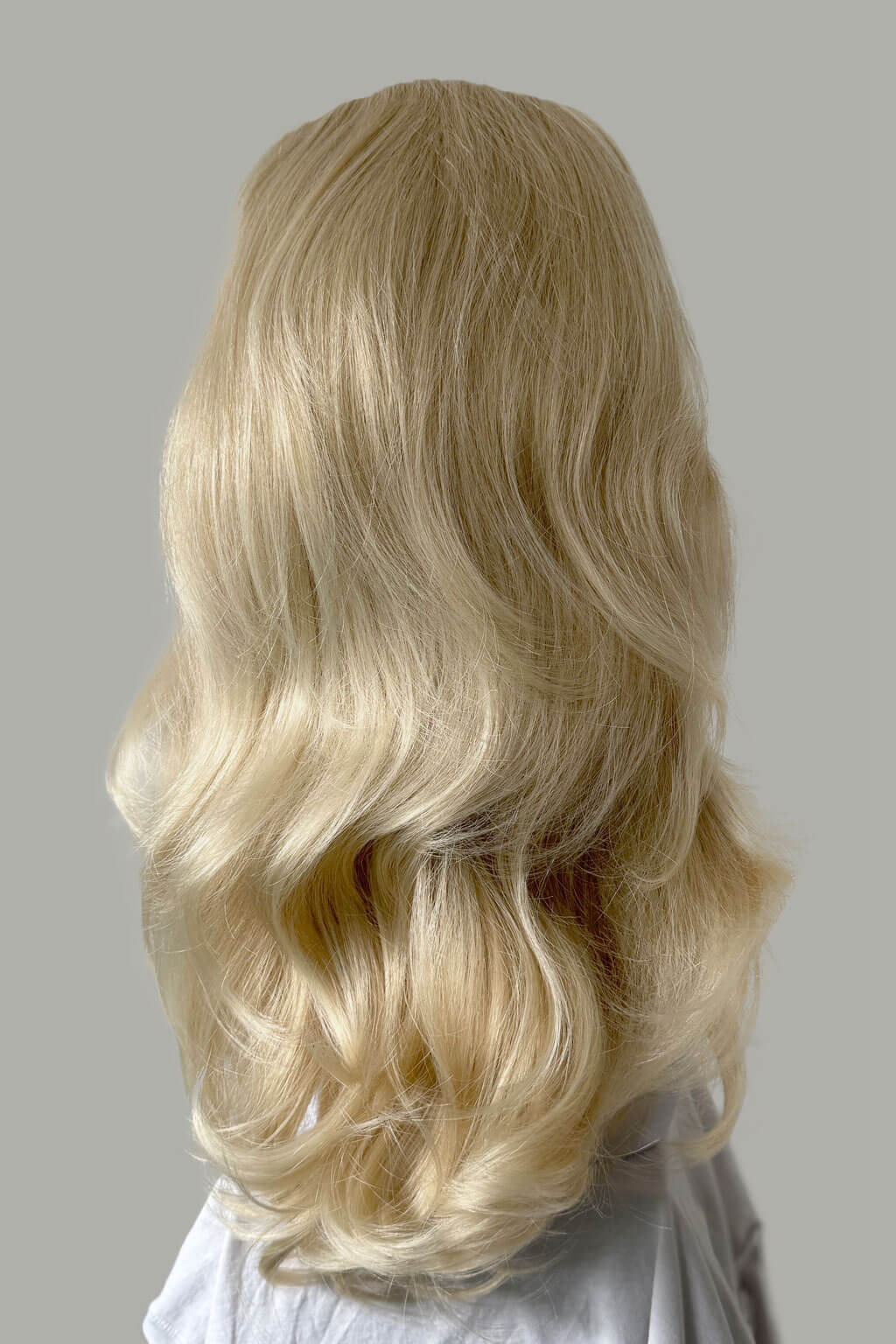 Blonde wig with wavy hair on a neutral background - High crown long, layered half wig and volume ring: Helena blonde 613T24