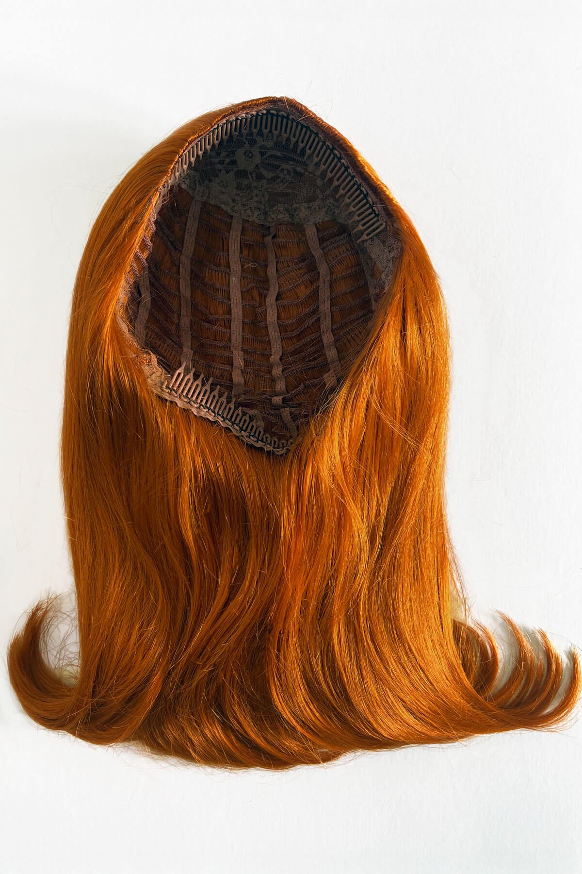 Orange hair extension on a white background. 1960s half wig hairpiece, flicked, hair flip: Philippa ginger