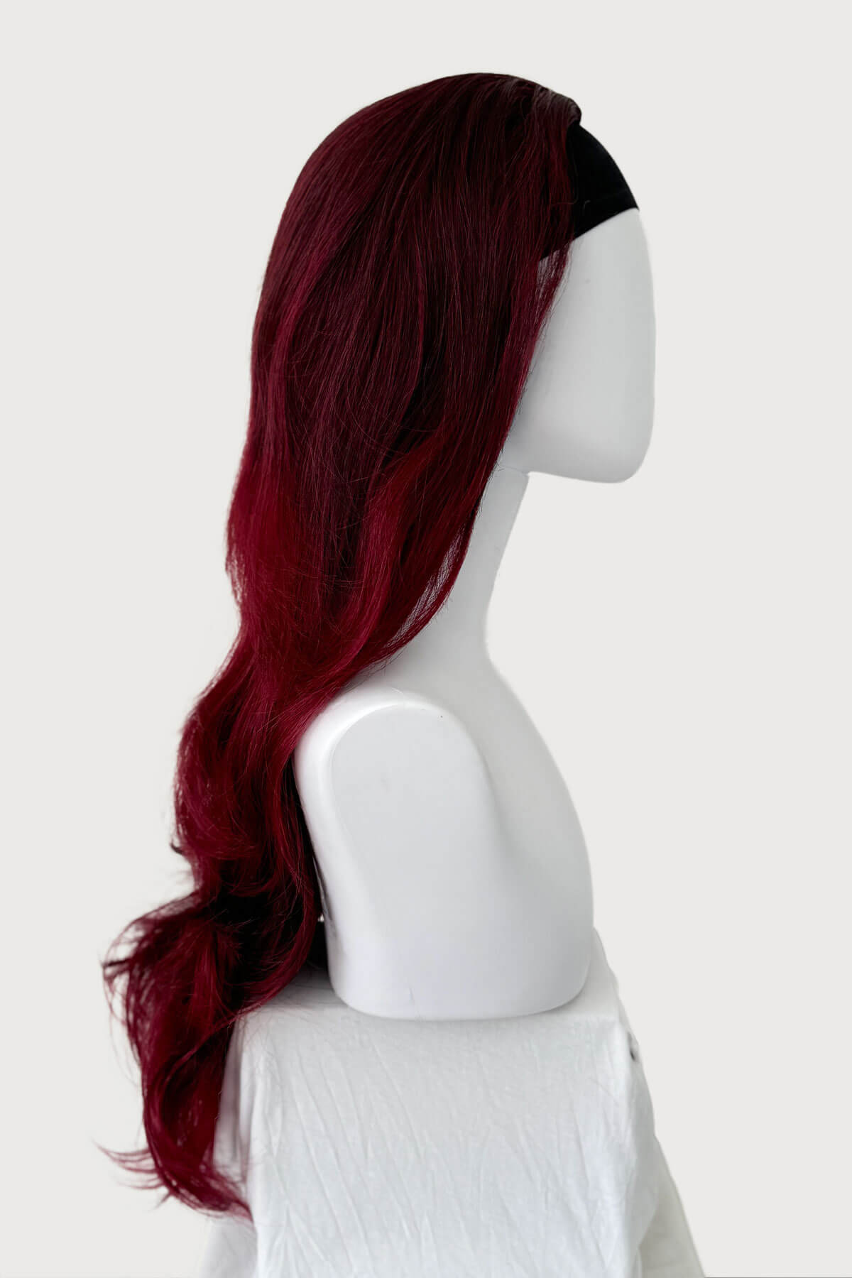 Mannequin head with a red and black wig on a white background. Black and red half wig hairpiece (3/4 wig), loose curls: Monica