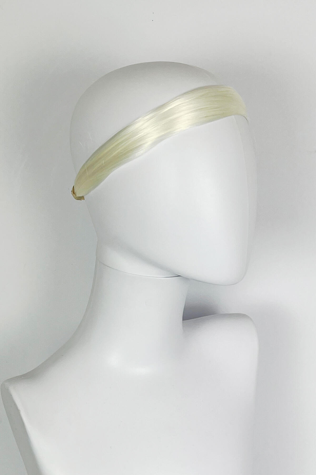 Platinum blonde headband on a mannequin head against a white background. Loose hair hairband: Mabel platinum blonde 1001