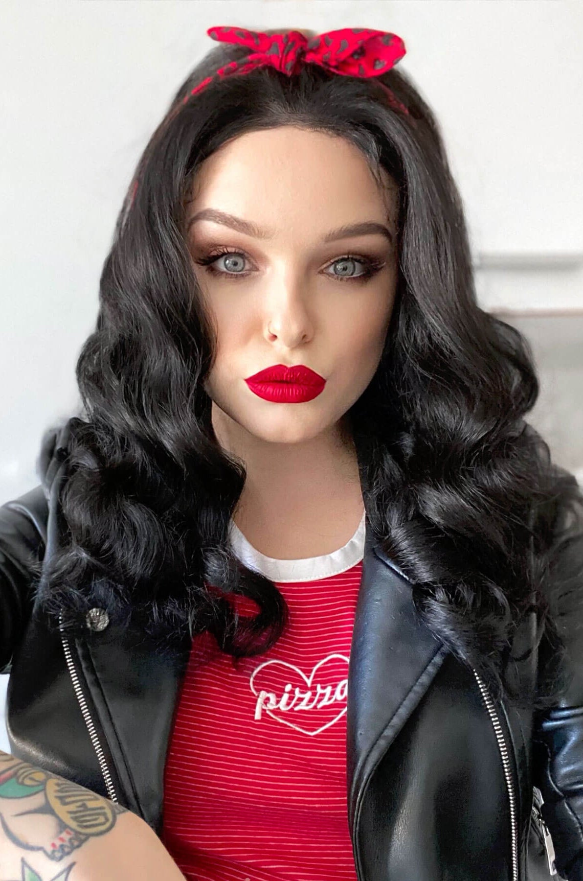 Mannequin head with black hair, red lipstick, and a black leather jacket over a red shirt, Black pinup wig, lace front with long finger waves: Tyra