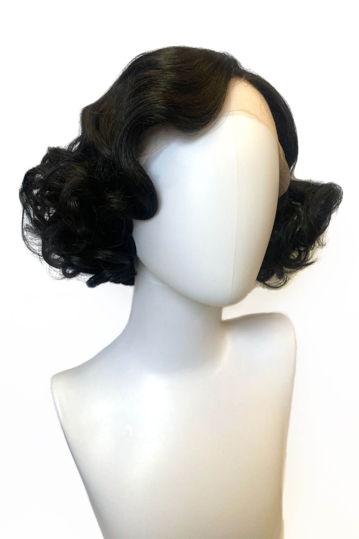 Black wig styled in curls on a mannequin head against a white background. Black pinup wig, lace front, vintage style: Halle