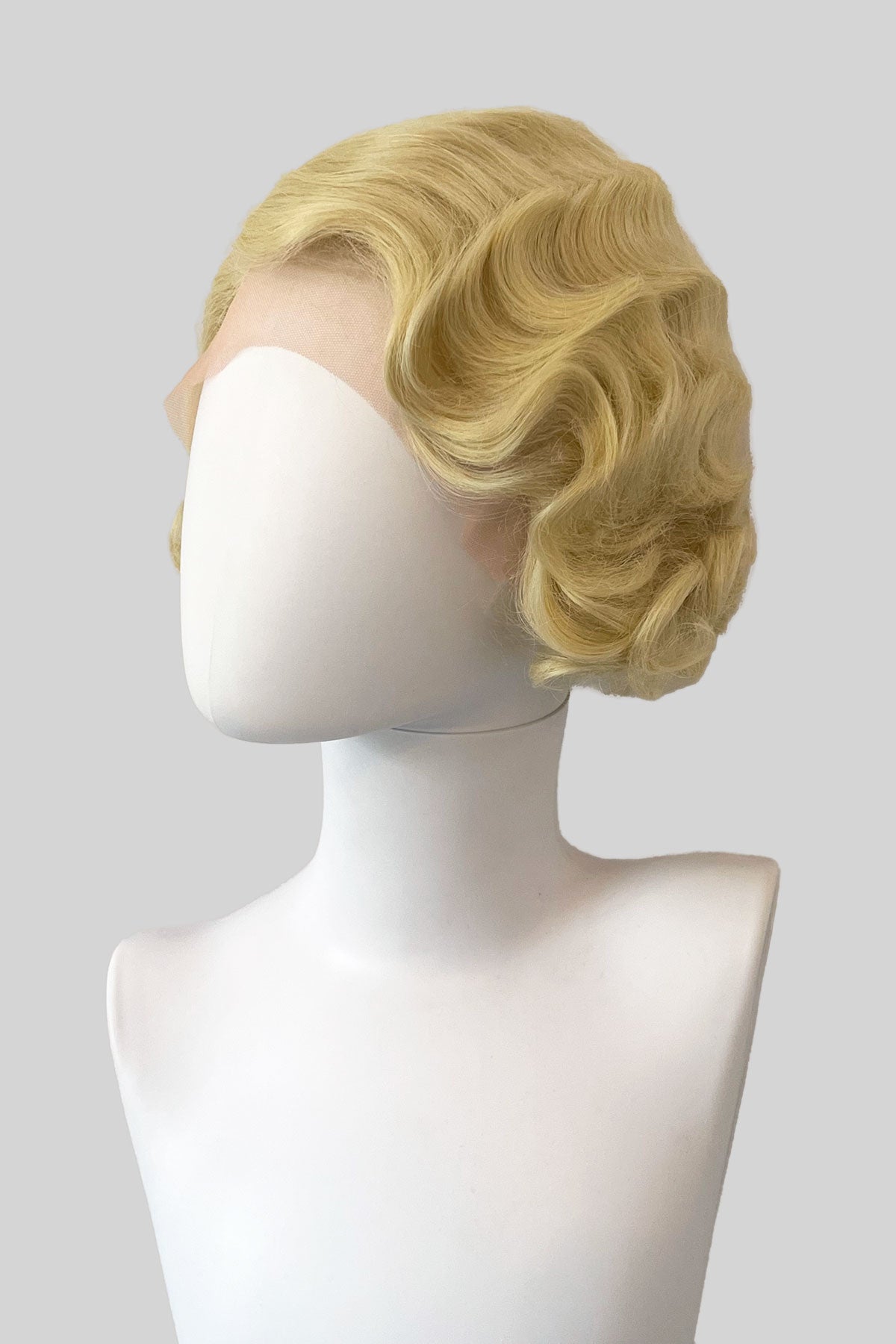 Blonde wig on a mannequin head with a white background. Blonde pinup wig, lace front, vintage style: Odette blonde 613
