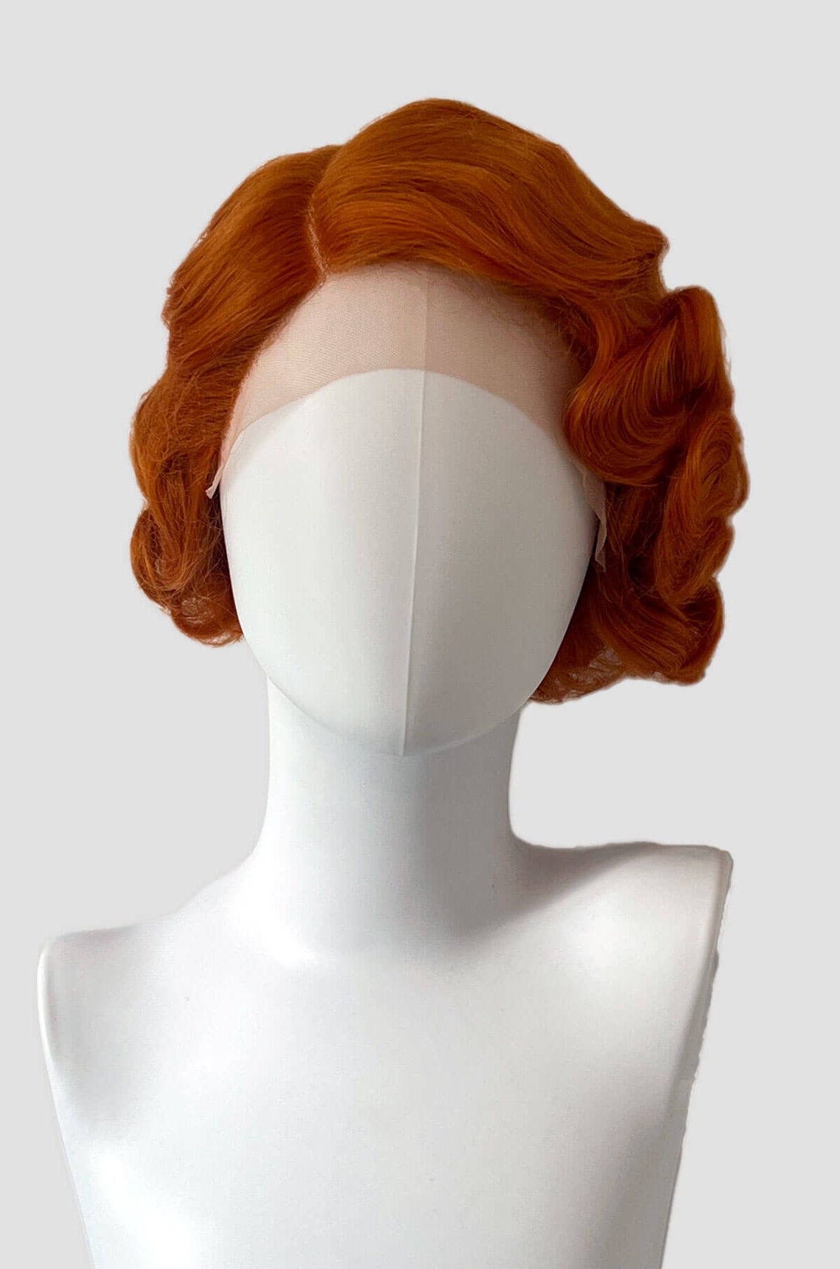Red wig on a mannequin head against a white background. Ginger pinup wig, lace front, vintage style: Flo