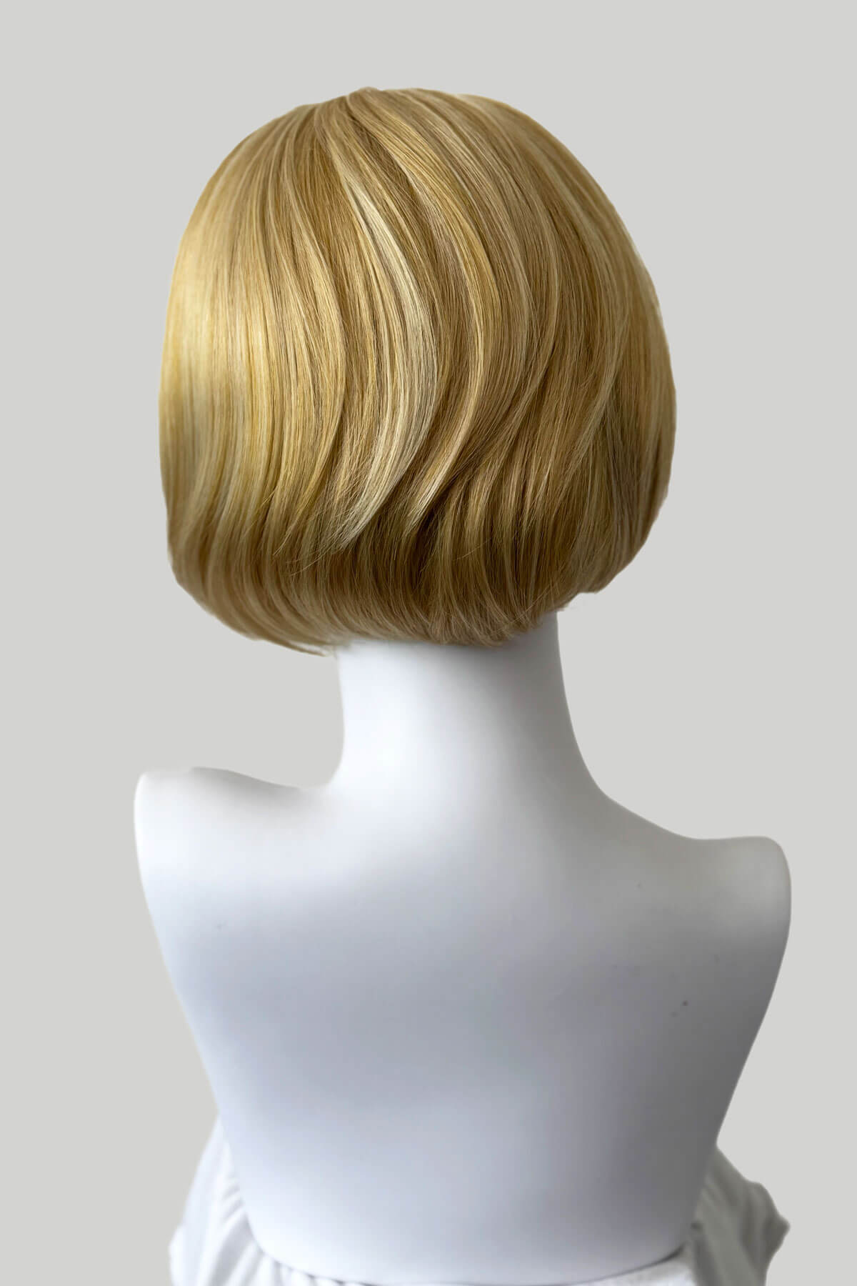 Blonde wig on a mannequin head against a white background. Bob half wig hairpiece, Flexihair: Amelie honey blonde 24BH613