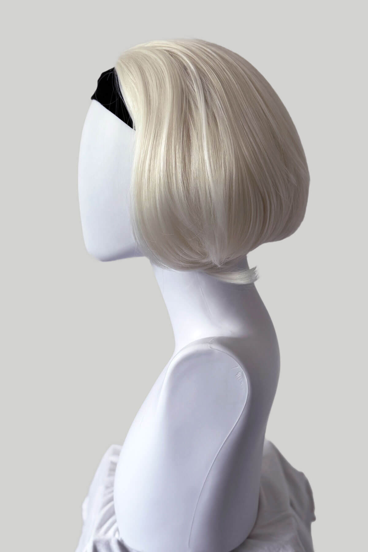 Mannequin head with a blonde wig on a plain background. Bob half wig hairpiece, heat styleable: Amelie platinum blonde 1001