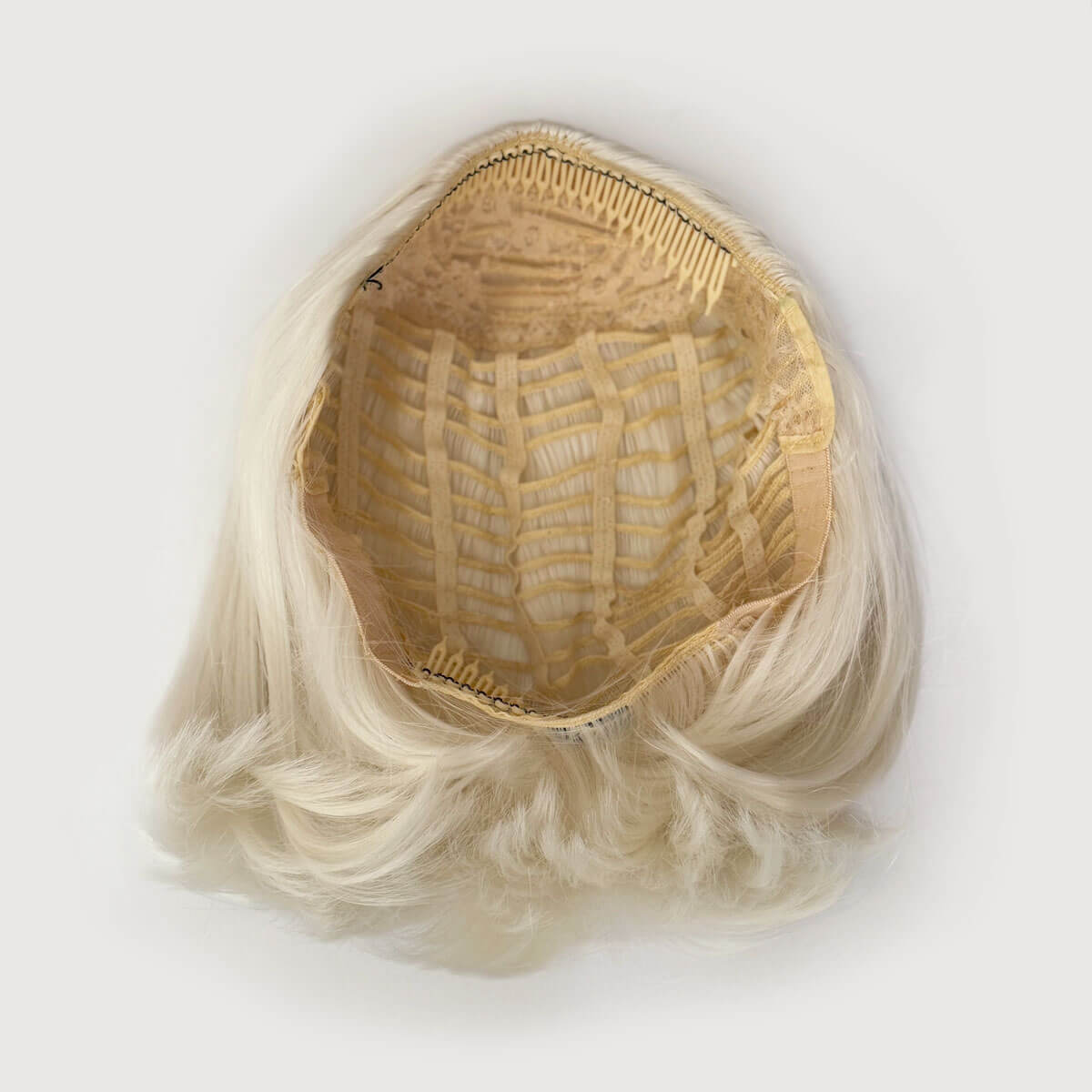 Blonde wig with a clear plastic cap on a white background. Bob half wig hairpiece, heat styleable: Amelie platinum blonde 1001