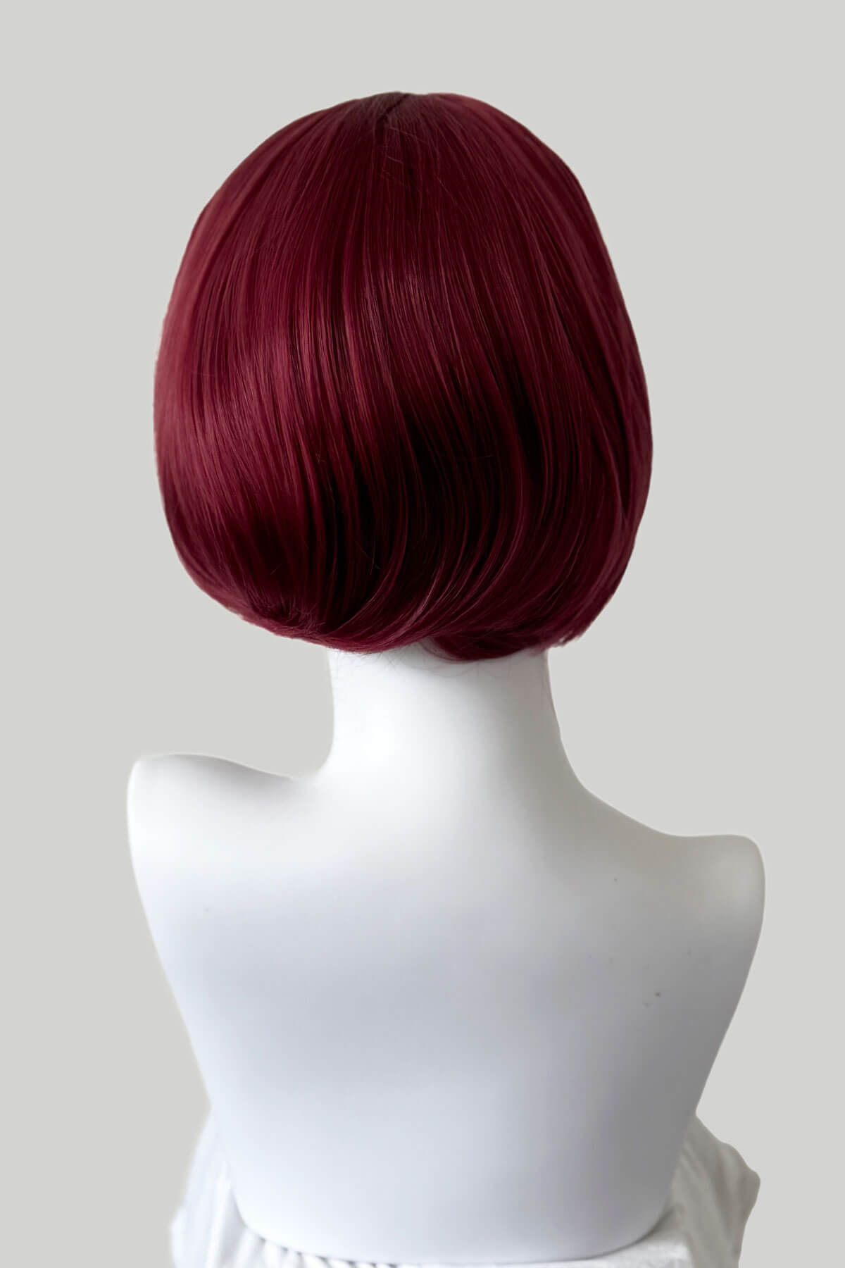 Red wig on a mannequin head against a white background. Bob half wig hairpiece, Flexihair: Amelie wine red 39
