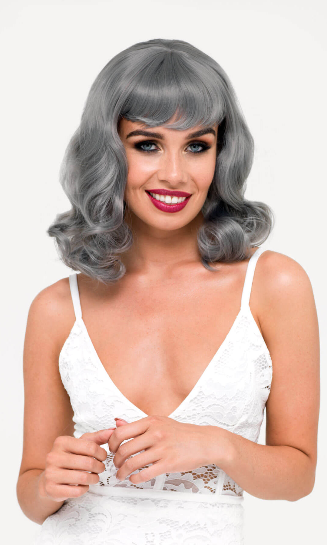 Woman wearing a gray wig with a white background. Silver-grey pinup style wig with long waves and short fringe, 1950s style: Dotty