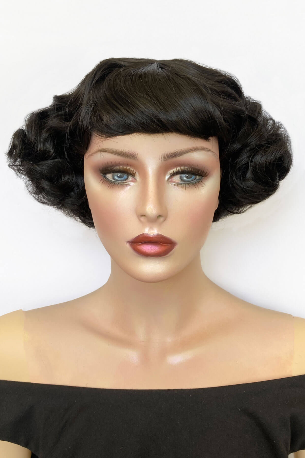 Mannequin head with a black wig on a white background. A short black vintage style wig with finger waves: Marlene