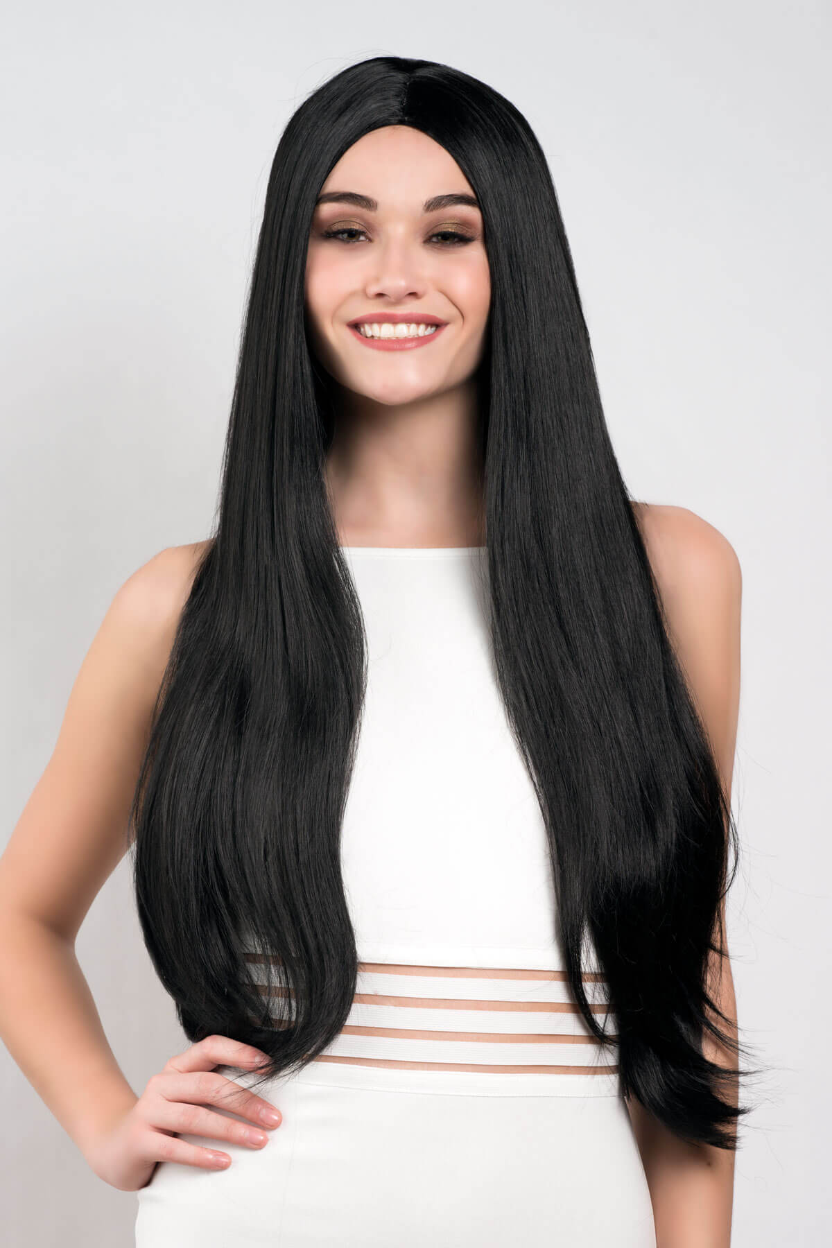 Woman wearing a black wig on a plain background. Long straight black wig with no fringe: Madeline
