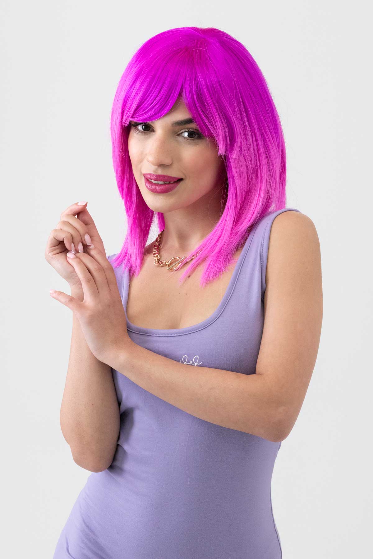 Woman with bright pink wig wearing a light purple dress on a white background. Pink dip dye wig (ombre), straight: Hetty