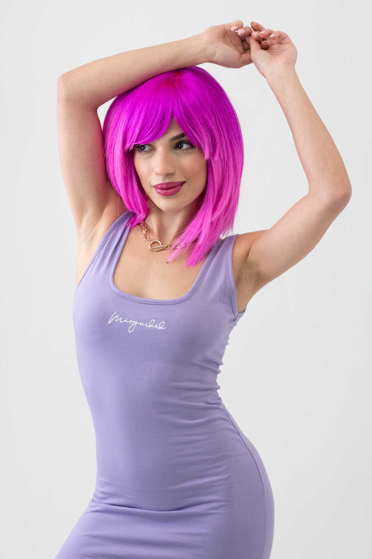 Woman wearing a purple tank top with text and a bright pink wig against a white background. Pink dip dye wig (ombre), straight: Hetty