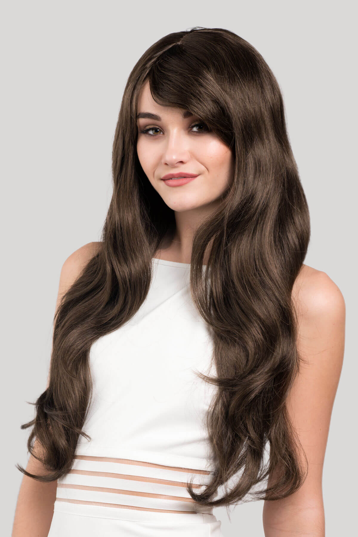 Woman with long, wavy brown hair wearing a white top on a light gray background. Long brown wig with loose waves: Mandy chestnut brown 8