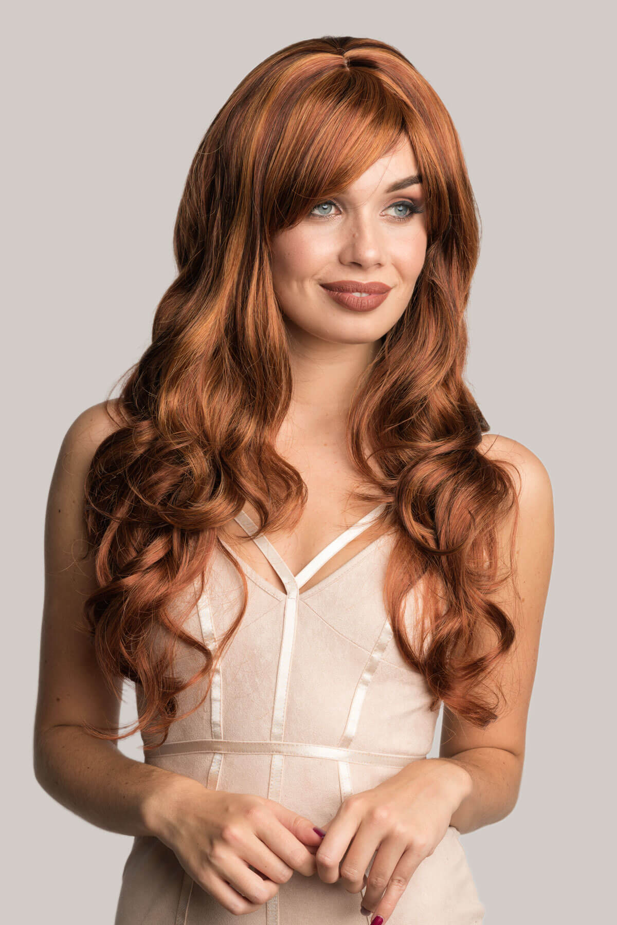 Woman with long, wavy red hair wearing a beige top against a plain background. Long red auburn and blonde wig: Amanda