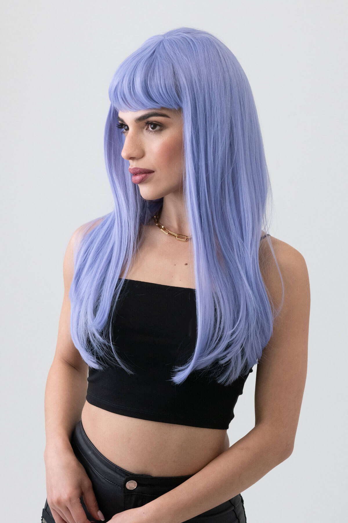 Woman with a long blue wig on a plain background. Long blue wig with short, straight fringe: Alyssa