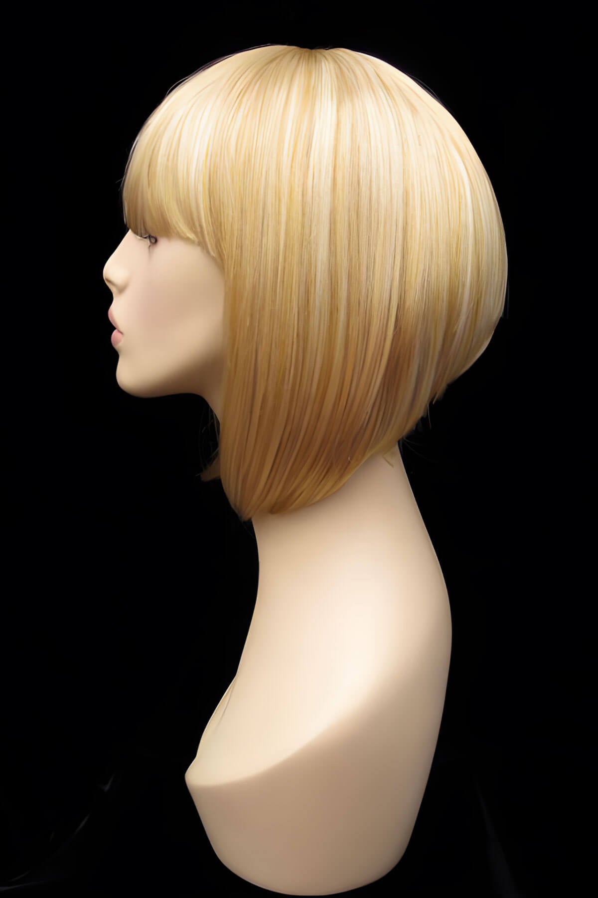 Mannequin head with a blonde wig on a black background. Blonde inverted bob wig: Rhiannon honey blonde 24BH613