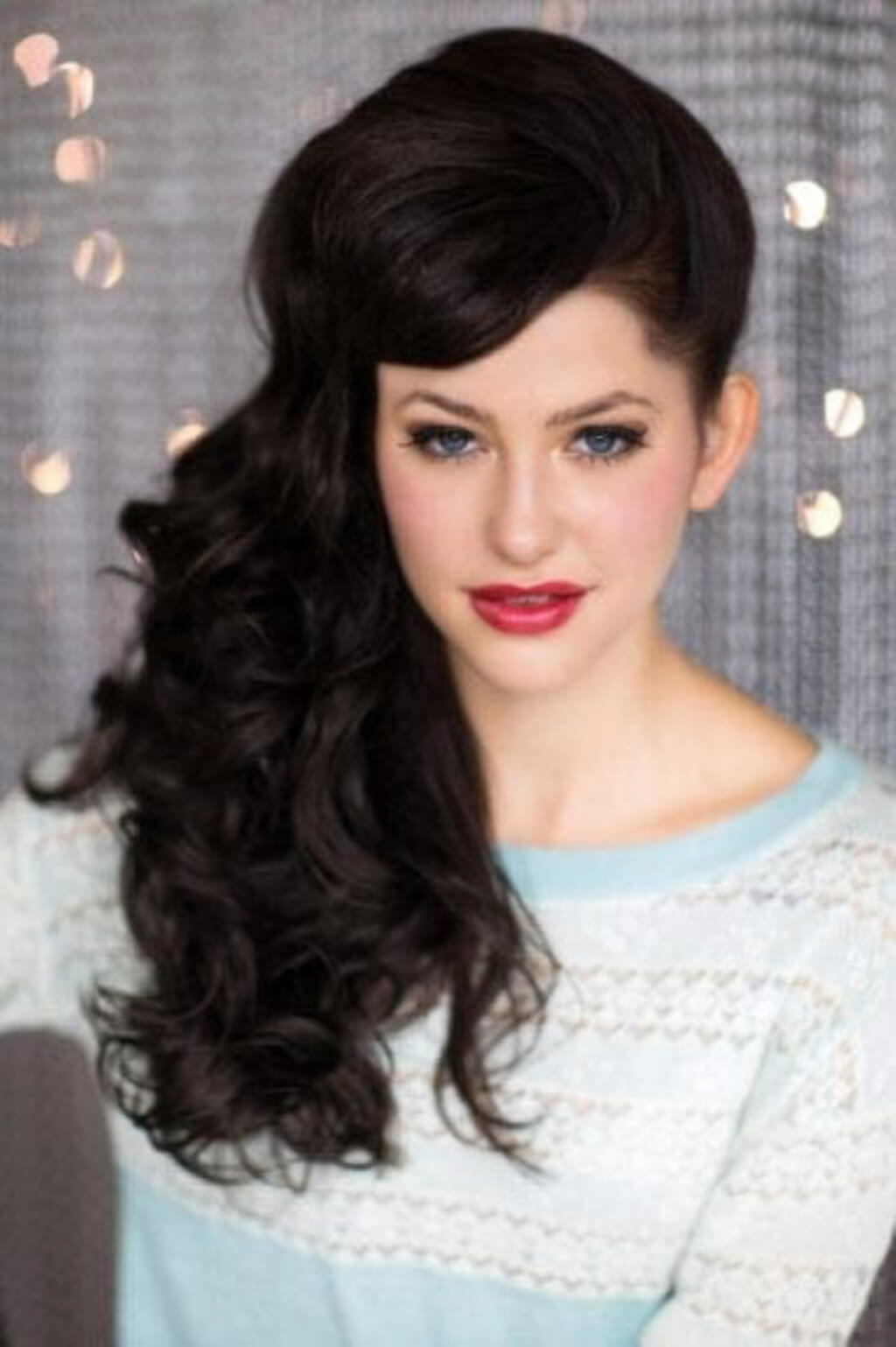 Woman with styled hair and makeup against a neutral background