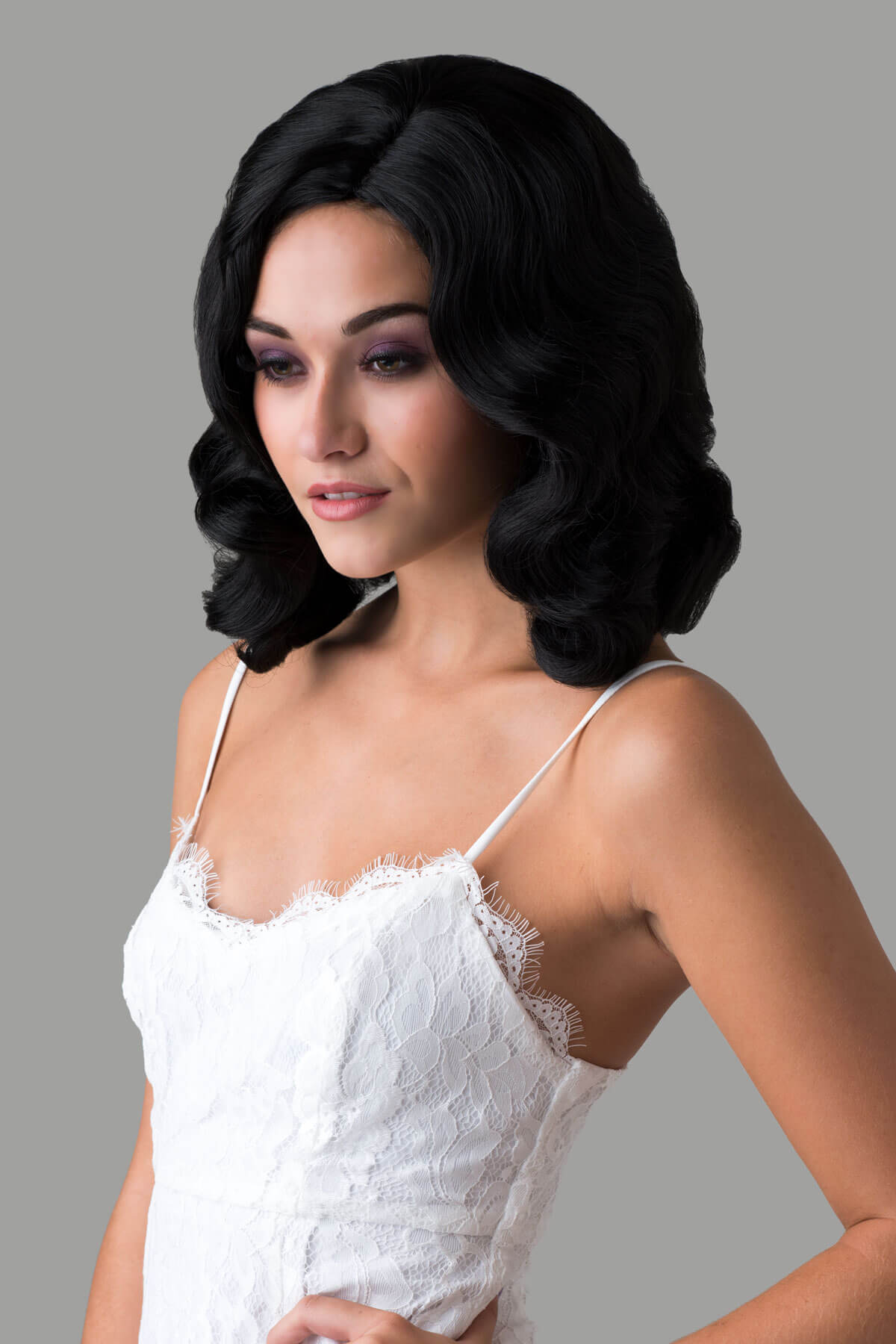 Woman wearing a black wig with a gray background. Black 40s style wig with beautiful marcel waves: Dita