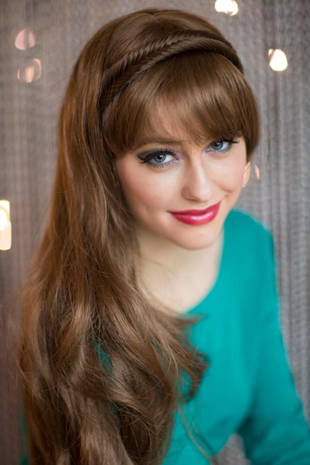 Woman with styled hair and headband against a neutral background