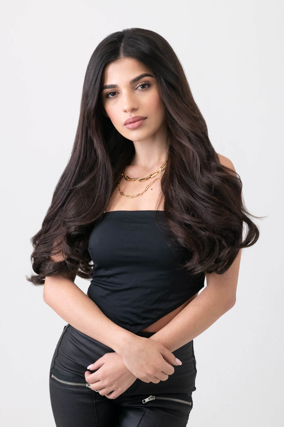 Woman with long dark hair wearing a black top against a white background. synthetic hair extension set, 5 piece, 18 inches long, 260g dark brown 4
