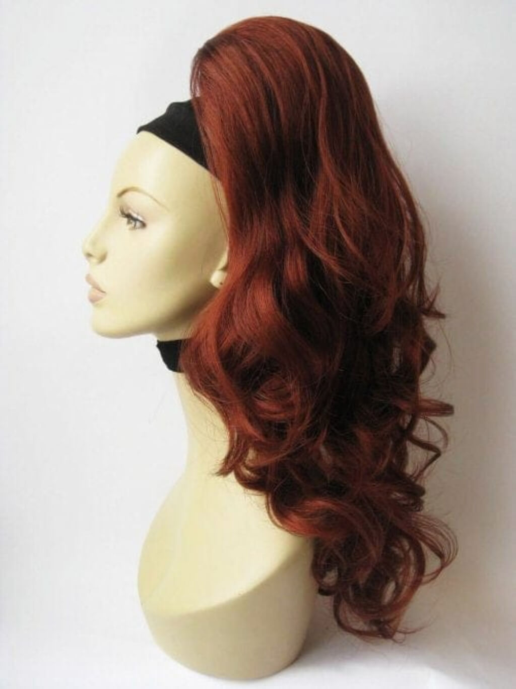 Red wig on a mannequin head against a white background. Synthetic hair piece copper red Wavy ponytail hairpiece extension: Casey copper 130