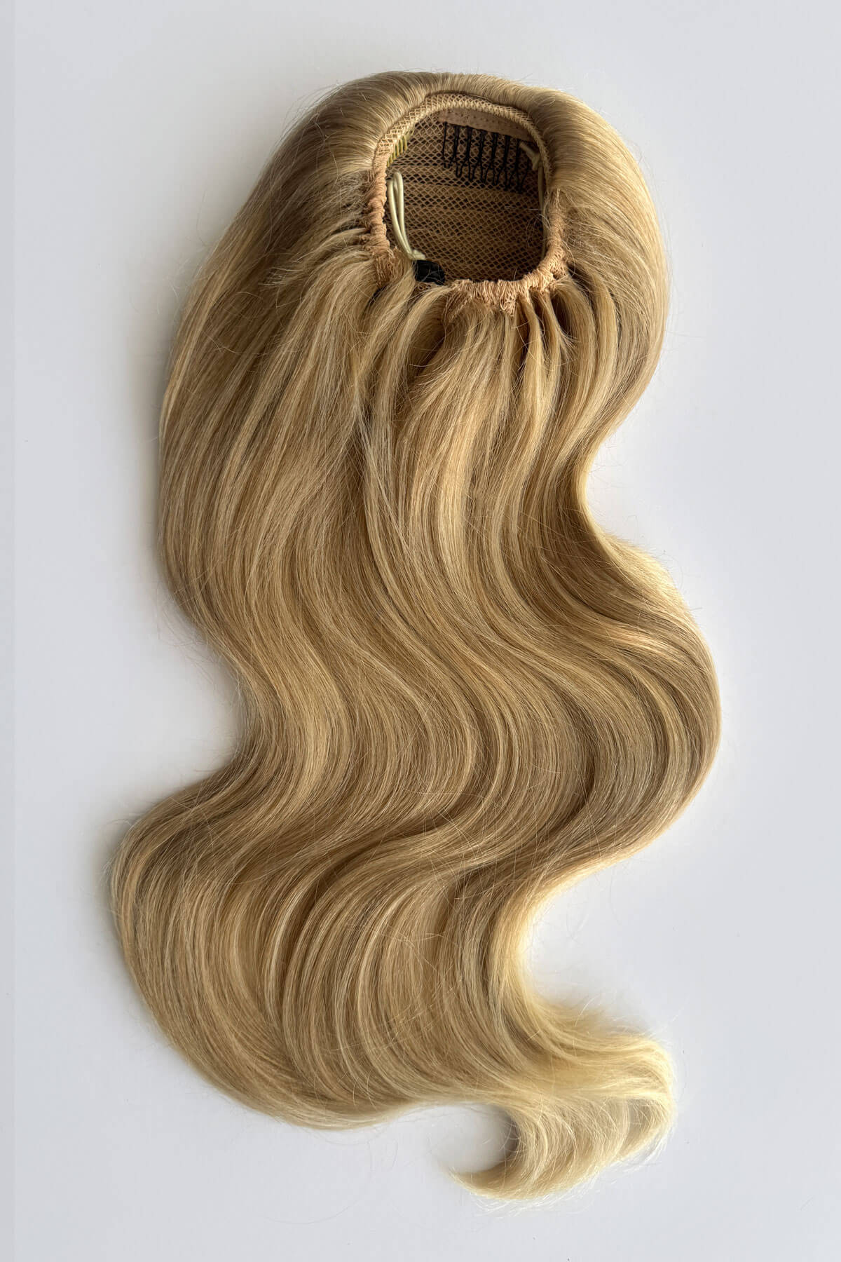 A wavy blonde hair piece with highlighted streaks and drawstring attachment, styled in loose curls, shown against a plain light grey background. Double volume hairpiece extension: Naomi blonde 613T24